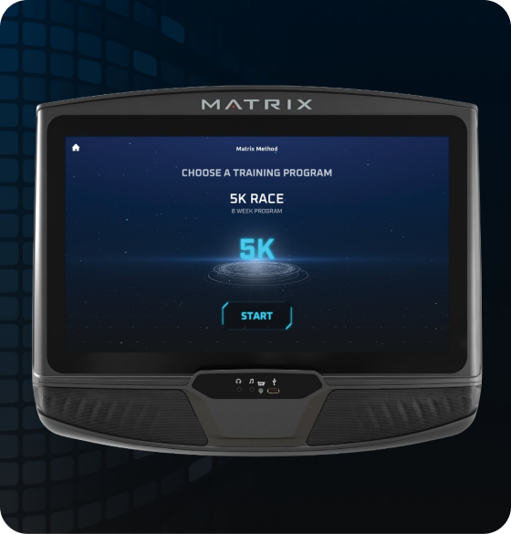 Image of a Matrix workout console. Screen has the Matrix Method starting screen indicating "Choose a Training Program'. Screen is currently selected on the 5K screen as is indicated by the glowing blue Characters above a sci-fi circles beneath. Start button is the last element on the page.