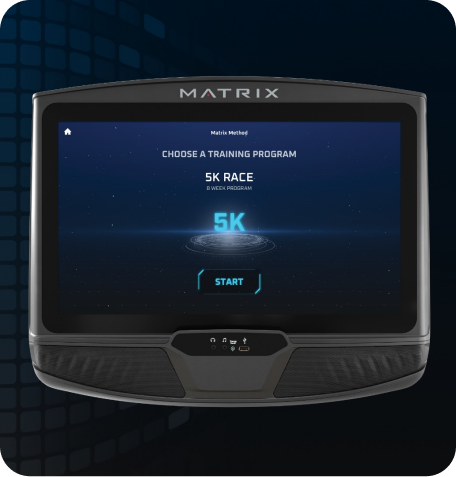 Image of a Matrix workout console. Screen has the Matrix Method starting screen indicating "Choose a Training Program'. Screen is currently selected on the 5K screen as is indicated by the glowing blue Characters above a sci-fi circles beneath. Start button is the last element on the page.